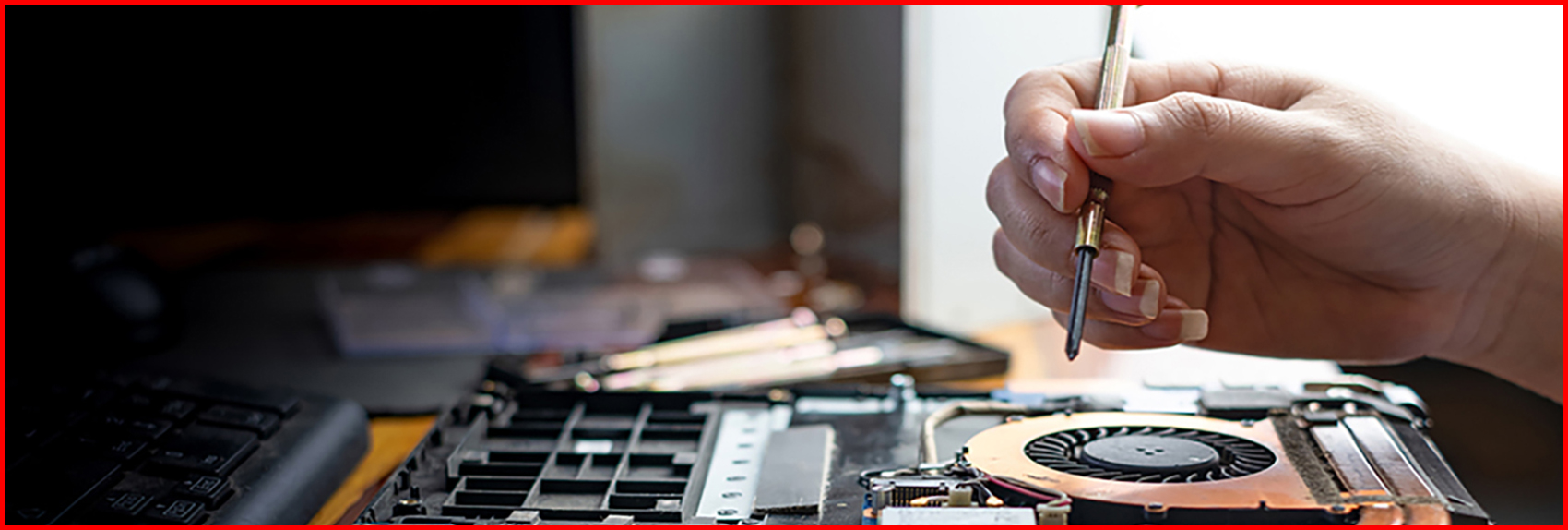 Technician repairing broken laptop notebook computer with screwdriver